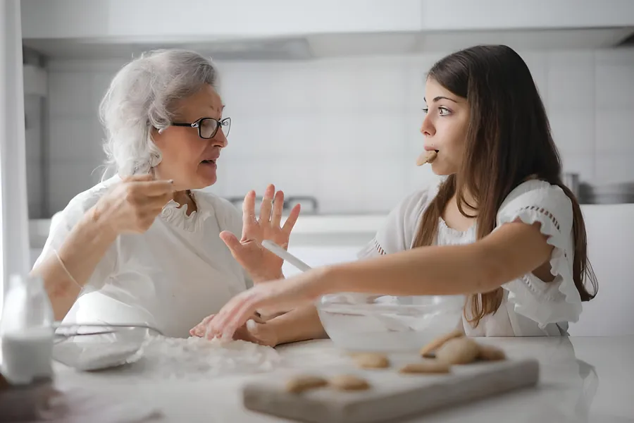 Oma en kleindochter bakken samen in de keuken
